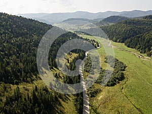 Road through mountains and forest captured from above