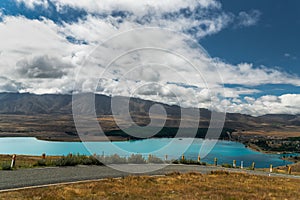 Road in the mountains, Lake Tekapo, and dramatic cloudy sky, North Island New Zealand