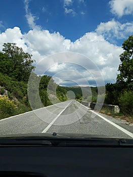 Road in the mountains seen from the windshield of the traveling car.  In particular this is a view in Abruzzo, Italy