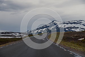 On the road with mountains with snow tops