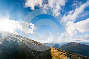 Road in the mountains, under a sunny sky. Cloudy. Mountain range clouds panoramic landscape. Autumn day in the mountains of