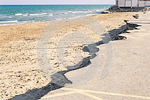 Road near the beach destroyed by a sea storm. Climate change