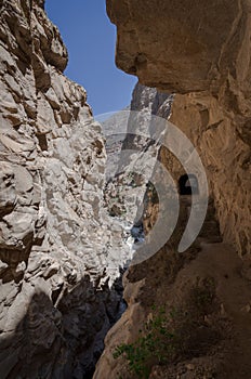 road next to the precipice that runs through natural rock tunnel, parallel to the river in the canyon of the duck