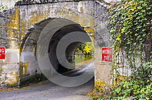Road through an old one-way arched concrete bridge