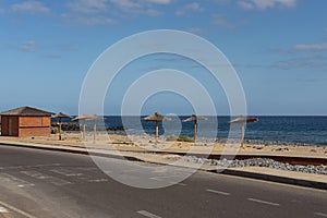 Road with old pedestrian crossing towards a golden manmade sand beach near the Atlantic, San Blas, Tenerife, Canary Islands