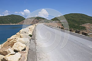 Road over the dam of the High Island Reservoir at the Hong Kong Global Geopark, Hong Kong, China.