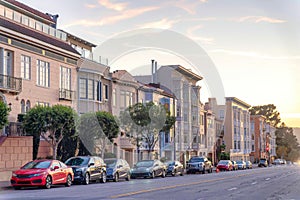 Road with parked vehicles at the front of residential buildings in San Francisco, CA