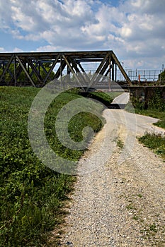 Road that passes under a railway bridge on a clear day in spring in the italian countryside