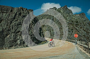 Road passing through rocky landscape with cyclist