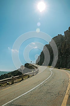 Road passing through rocky landscape in a sunny day