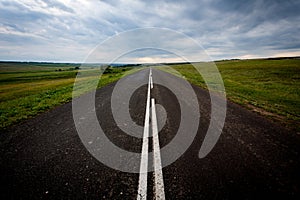 Asphalt road with fresh markings rests against the clouds