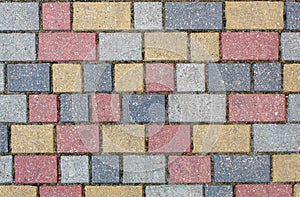 Road paved with gray, yellow and brown sidewalk tiles. texture of light colored bricks