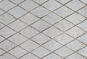 Road paved with rhombus sidewalk tiles. texture of light gray bricks