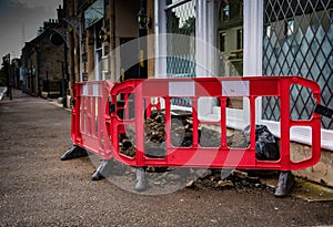Road pavement excavation work area with red safety barriers