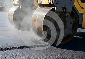 Road paving machine compacting asphalt