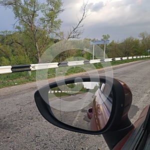 On road. Rear-view mirror on the driver`s side