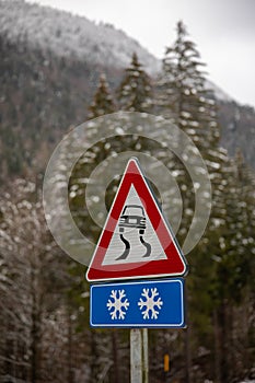Road with Reduce speed now sign during snow fall of winter 2020