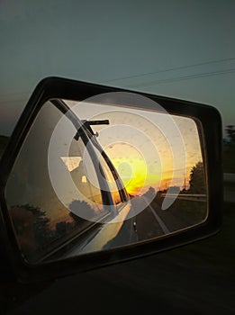 Road reflection in the car side mirror. Travel lifestyle vertical photo