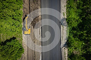 Road repairs. Excavator bucket removes soil along the roadbed