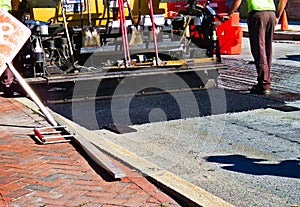 Road repaving: paver laying down fresh asphalt. photo