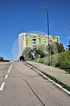 Road in a residential area with a building on its side
