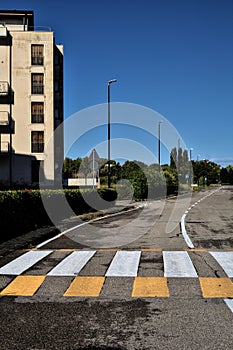 Road in a residential area with a building on its side