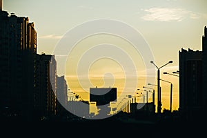 Road and residential buildings in city at sunset