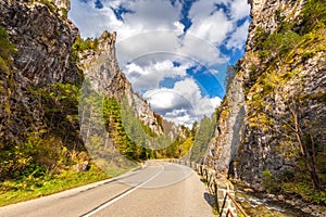 Road through a rocky gorge in a mountain valley at autumn