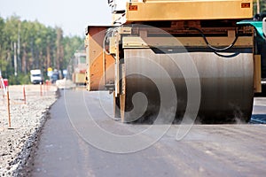 Road roller compacting asphalt pavement