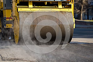 Road roller compacting asphalt during road repairs.
