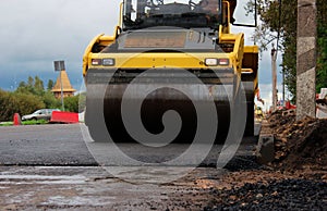 road roller compactor at work. asphalt pavement works for road repairing. expansion and repair of the roadway at the