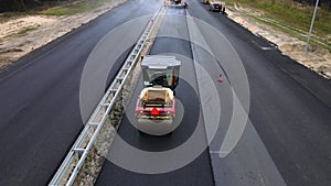 Road roller compacts and levels the new hot asphalt. Pavement repair technology
