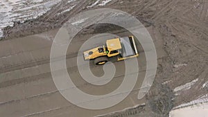 A road roller is driving on a construction site.