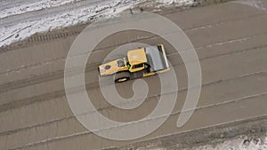 A road roller is driving on a construction site.