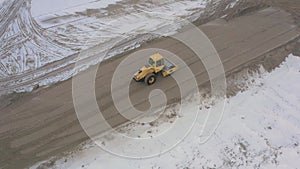 A road roller is driving on a construction site.