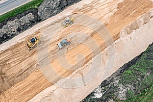 Road rollers and bulldozer work on construction site. aerial top view