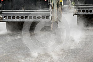 Road rolling machines working with steam on the asphalt