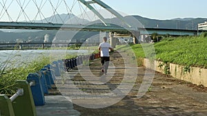 Road runner caucasian man running near the river in Taipe city