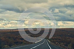 Road running between arctic hills. Autumn season