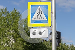 Road sign adjustable pedestrian crossing in blue with a badge for blind pedestrians in the form of black glasses.