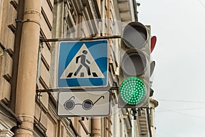 adjustable pedestrian crossing in blue with a badge for blind pedestrians in the form of black glasses