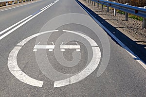 A road sign on the asphalt in front of the bridge prohibits overtaking photo