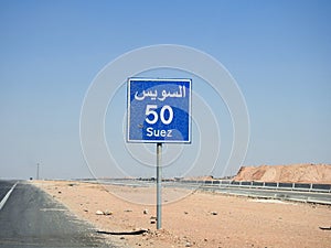 A road sign board in Suez Cairo highway gives the remaining distance to Suez city 50 KM fifty kilometers written in English and
