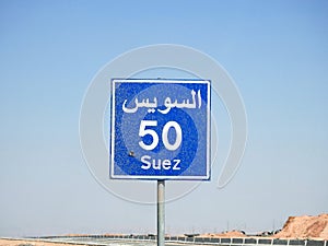 A road sign board in Suez Cairo highway gives the remaining distance to Suez city 50 KM fifty kilometers written in English and