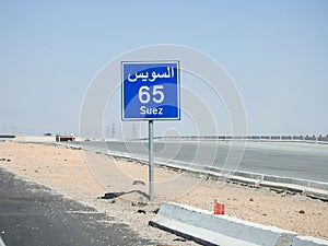 A road sign board in Suez Cairo highway gives the remaining distance to Suez city 65 KM sixty five kilometers written in English