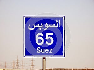 A road sign board in Suez Cairo highway gives the remaining distance to Suez city 65 KM sixty five kilometers written in English