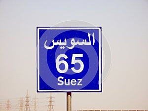 A road sign board in Suez Cairo highway gives the remaining distance to Suez city 65 KM sixty five kilometers written in English