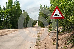 Road sign caution tanks on a country road in the woods