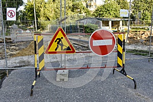 road sign, detour, road repair on the background of the road and broken asphalt covering on the urban street