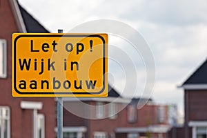 Road sign with Dutch text houses under construction